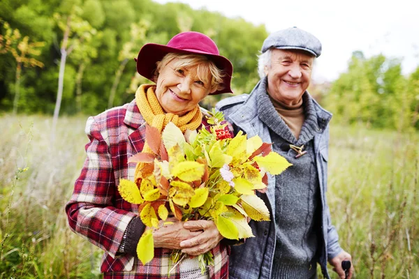 Äldre kvinna med hösten lämnar — Stockfoto