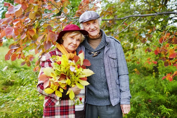 Äldre kvinna med höstlöv — Stockfoto