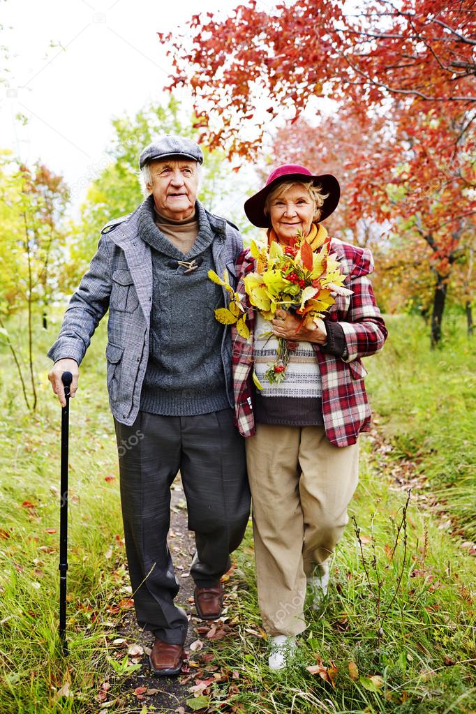 Retired couple walking in autumn park