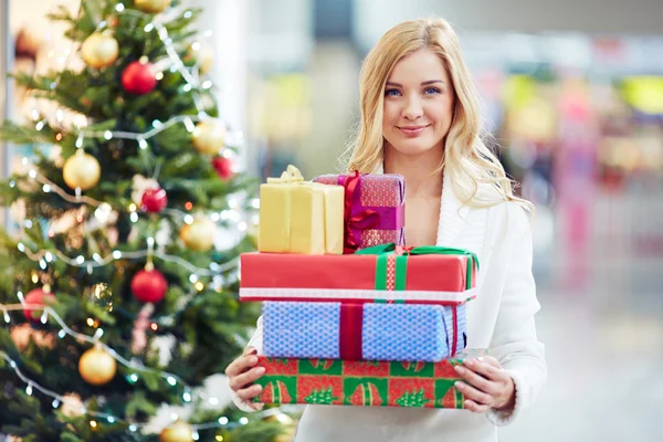 Kvinna med hög med julklappar — Stockfoto