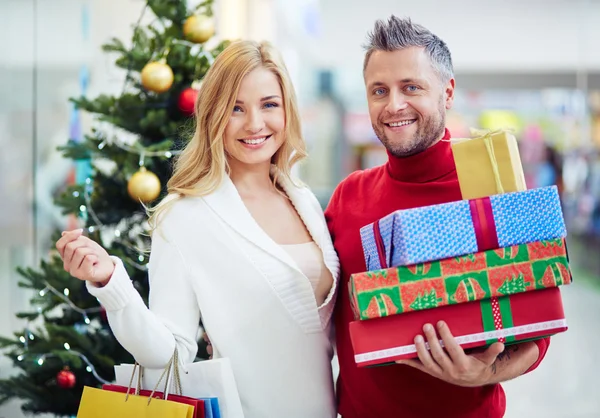 Casal com presentes de Natal no shopping — Fotografia de Stock