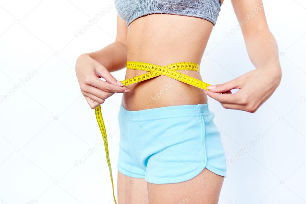 woman measuring size of  waist with tape