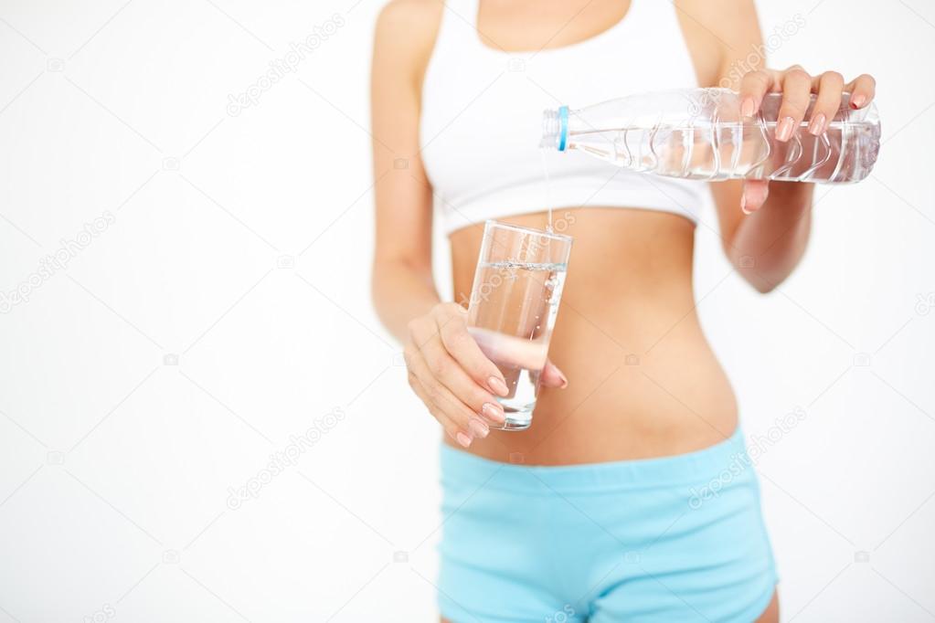 Fit woman pouring mineral water