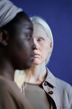 Siyahi ve Kafkasyalı kadınların yüzlerinin yarısı görünür vaziyette dikey odak çekimleri.