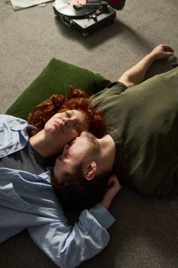 Kafkasyalı genç bir kadının göğüs kafesinde uzanmış kıvırcık kızıl saçlı ve genç bir adamın dinlenirken çekilmiş dikey pozu.