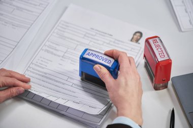 Vize merkezinde onaylanmış vize damgalı kadın el damgası yakın plan, masaya yerleştirilmiş pul reddedilmiş, başvuru belgesinde görünür fotoğraf