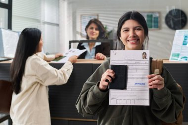 Onaylanmış vize başvurusu ve pasaport ile gülümseyen İspanyol kadının portresi