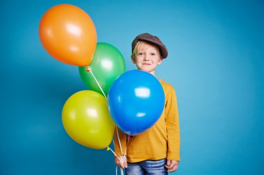 Küçük çocuk holding renkli balonlar
