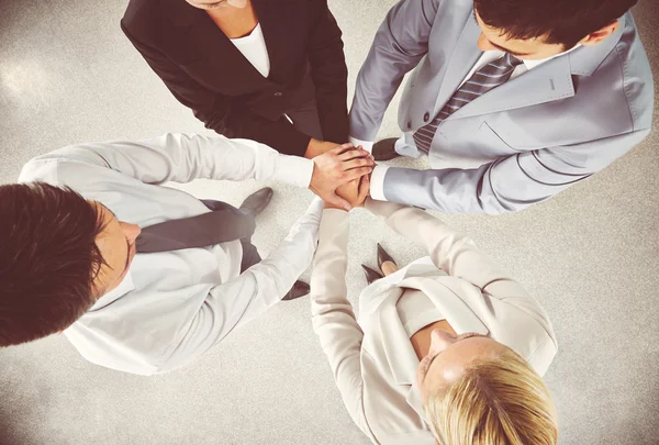 Equipo de negocios manteniendo sus manos en la pila — Foto de Stock