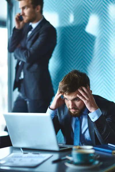 Stressad affärsman tittar på laptop — Stockfoto
