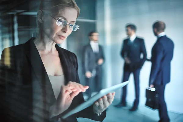 Businesswoman in eyeglasses using digital tablet — Stock Photo, Image