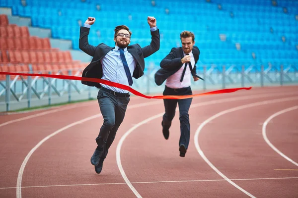 Businessman reaching finish at stadium — Stock Photo, Image