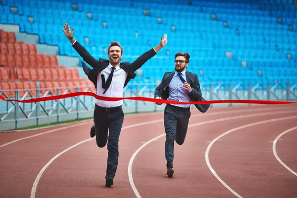 Businessman reaching finish at stadium — Stock Photo, Image