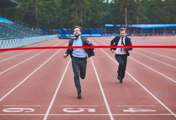 Businessman reaching finish at stadium — Stock Photo, Image