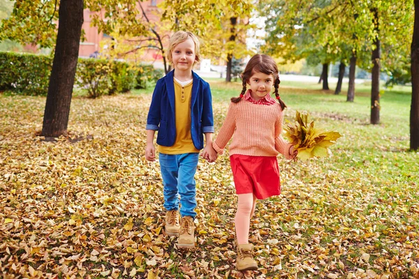 Små vänner gå i höst park — Stockfoto