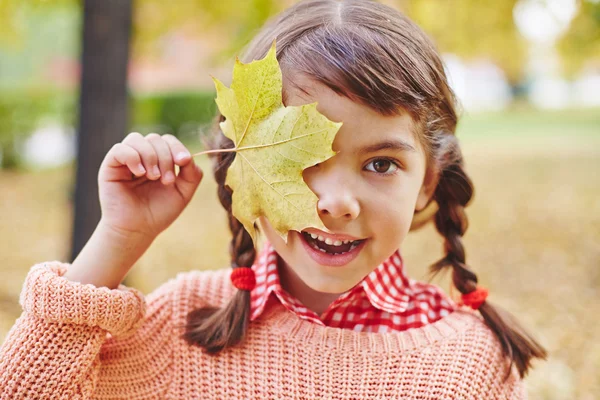 Lány a maple leaf által a szeme — Stock Fotó