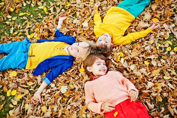 Friends lying on leaves autumn — Stock Photo, Image