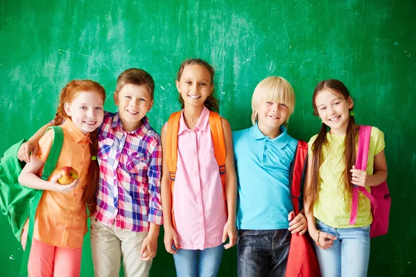 Kinder mit Rucksäcken stehen in Reihe — Stockfoto