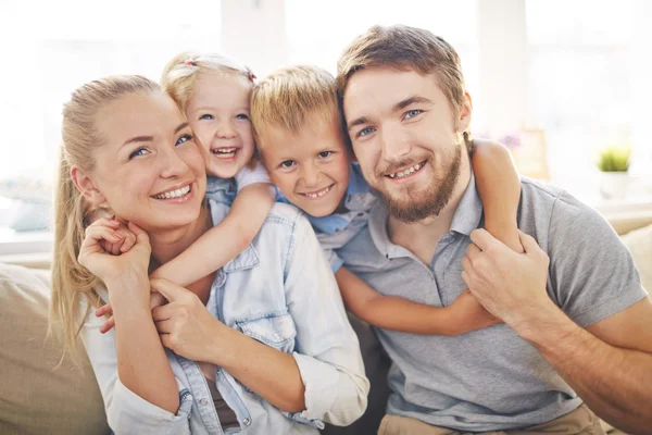 Broers en zussen omarmen hun vrolijke ouders — Stockfoto