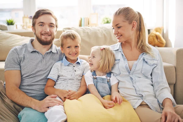 Familj i casualwear sitter på soffan — Stockfoto