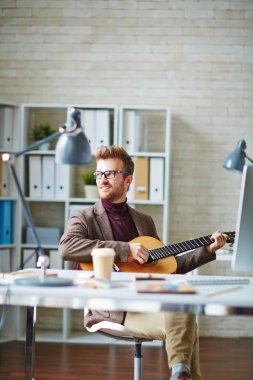 İşyerinde oturup gitar ile işadamı