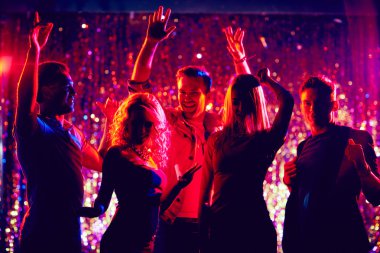 Gençler gece kulübünde dans ediyor.