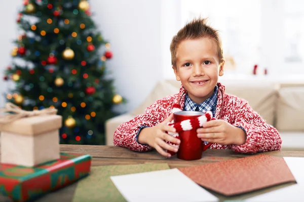 Pojke med kopp nära julgran — Stockfoto