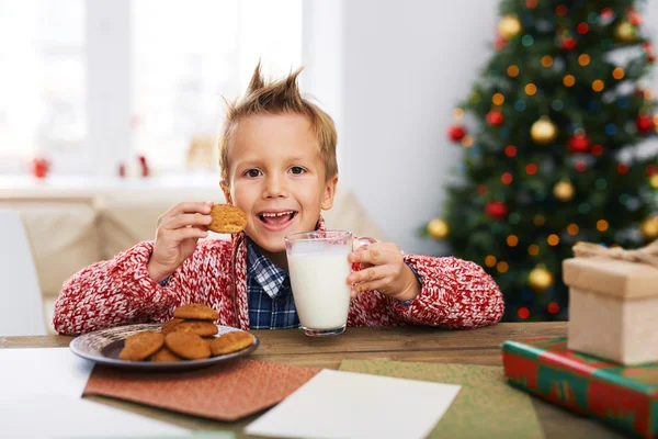 Jongen eten koekjes met melk — Stockfoto