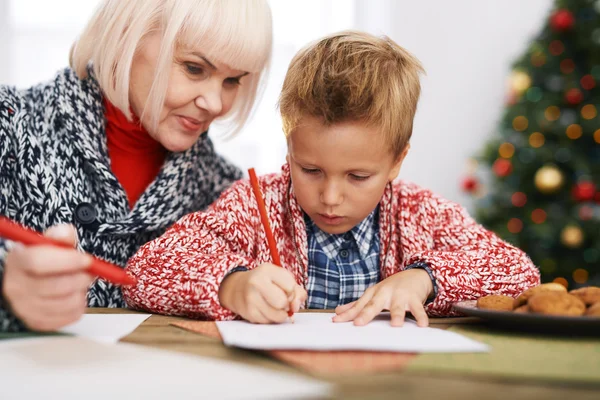 Mature woman looking at her grandson drawing — Stock Photo, Image