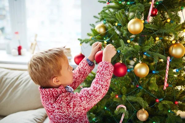 クリスマスツリーを飾る小さな男の子 — ストック写真