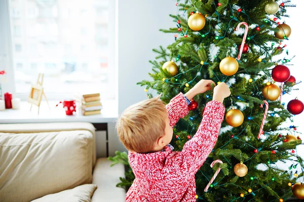 クリスマスツリーを飾る小さな男の子 — ストック写真