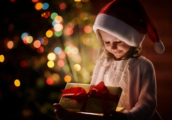 Petite fille en bonnet Santa avec cadeau — Photo