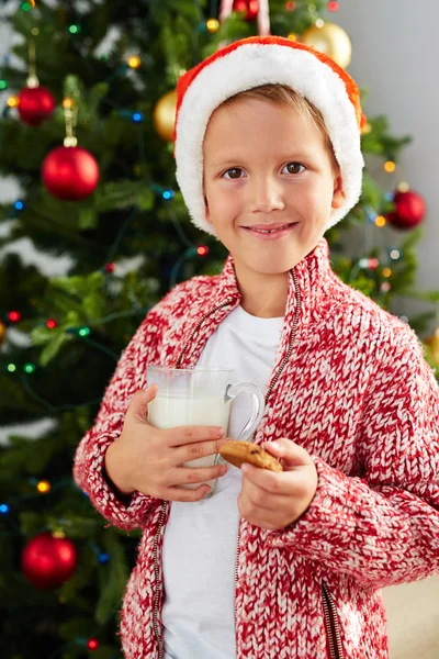 Oy in kerstmuts met een glas melk — Stockfoto