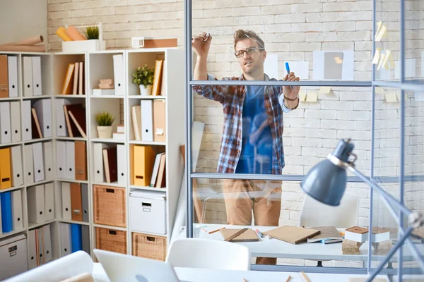 Ontwerper schrijven van notities op glas grens — Stockfoto