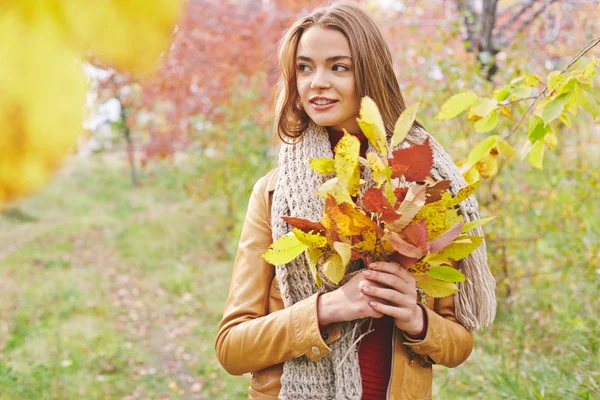 Женщина с жёлтыми осенними листьями — стоковое фото