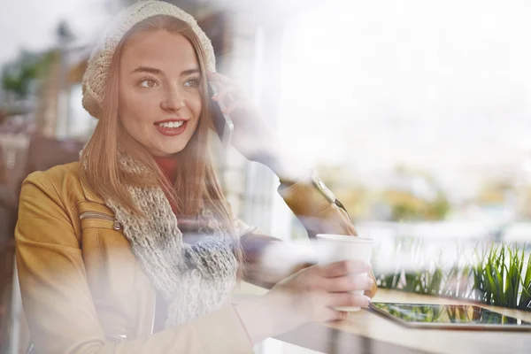 Meisje praten over cellphone in café — Stockfoto