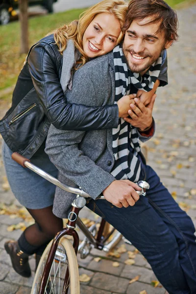 Ragazza abbracciando il suo fidanzato in bicicletta — Foto Stock