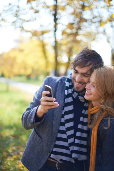 Pár, takže selfie v podzimním parku — Stock fotografie