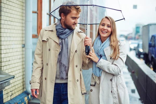 Мужчина и женщина ходят под зонтиком — стоковое фото