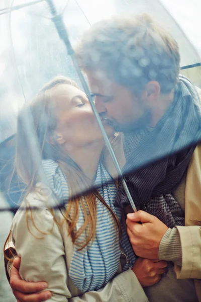 Casal beijando sob guarda-chuva — Fotografia de Stock