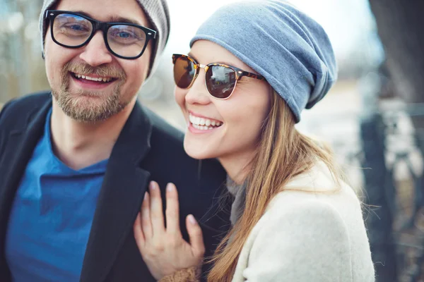 Couple heureux en casquettes et lunettes — Photo