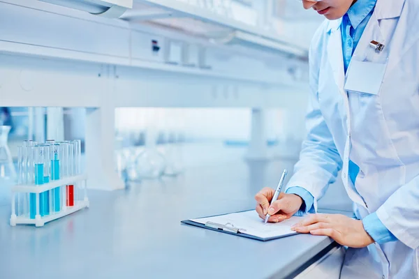 Trabajador de laboratorio toma notas — Foto de Stock