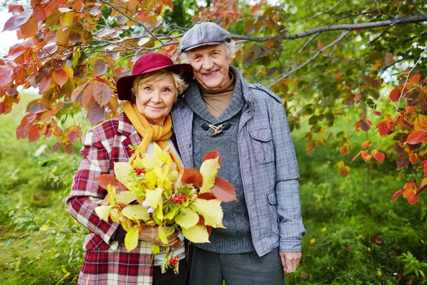 Donna anziana con foglie di autunno — Foto Stock