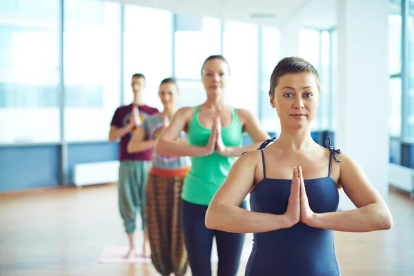 Kobieta robi ćwiczenia jogi z grupy osób — Zdjęcie stockowe