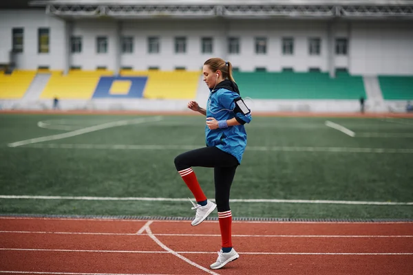 Woman flexing muscles in the stadium — Stock Photo, Image