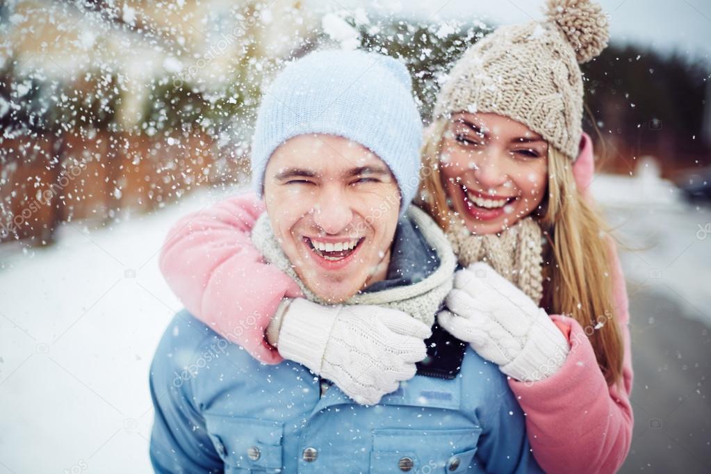 guy and girl  enjoying snowfall