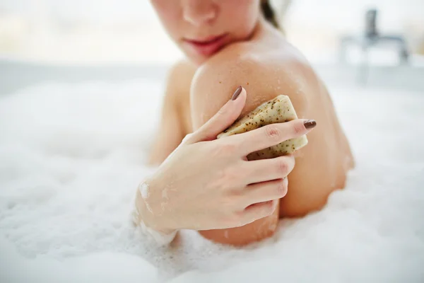 Ung kvinna skrubba hennes hud — Stockfoto