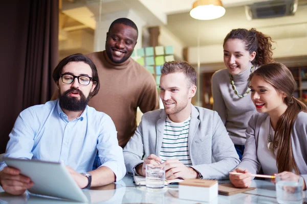 Junge Mitarbeiter schauen auf Touchpad — Stockfoto