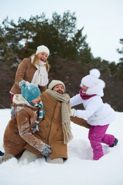 çocuklar ve ebeveynler rüzgârla oluşan kar yığını içinde eğleniyor