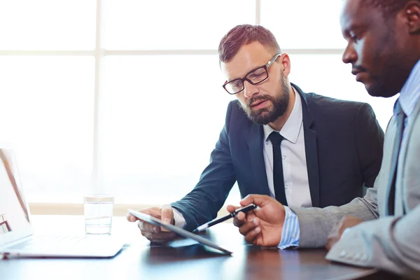 Jungunternehmer schaut auf Touchpad — Stockfoto